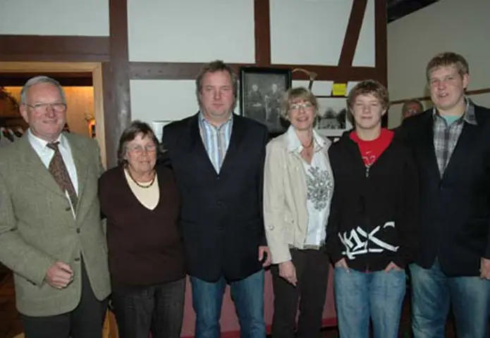 Das Foto zeigt sechs Personen verschiedener Generationen, die gemeinsam in einem historischen Gebäude von Hof Bimöhlen stehen. Die Aufnahme vermittelt den familiären Charakter und die generationsübergreifende Tradition des landwirtschaftlichen Betriebs.