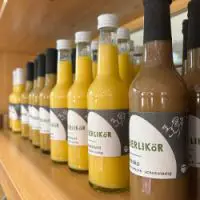 Flaschen mit hausgemachtem Eierlikör, Haselnusslikör und Schokolikör in einem Holzregal vom Hof Bimöhlen..